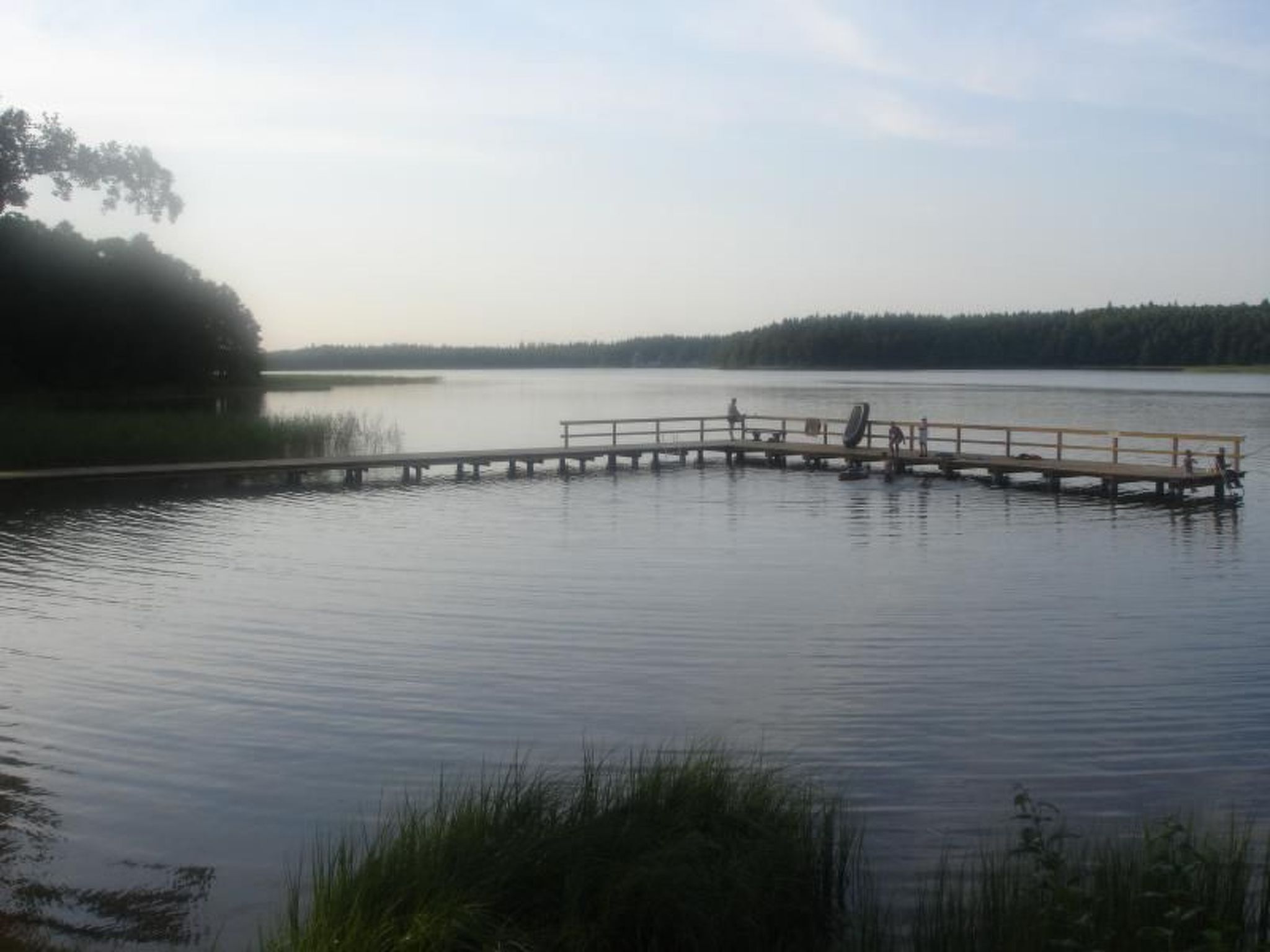 Un lago tranquillo con un molo di legno che si protende nell'acqua.