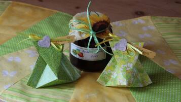 A bottle of wine with a label, two small gift bags, and a decorative item on a tablecloth.
