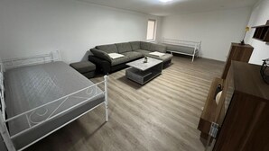 Ein Zimmer mit Bett, Schlafsofa, Couchtisch und Fernseher.