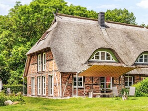 A traditional thatched-roof house with a brick facade, large windows, and a covered porch area. - Reethaus Mertinat ''For Ten'' mit Meerblick by Interhome (Gollwitz (Insel Poel))