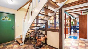 Un escalier avec des poutres en bois et une porte verte.