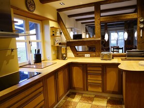 Een koelkast, een oven, een vaatwasser, kookgerei, borden en bestek