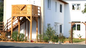 A two-story building with a wooden deck and a staircase leading to the upper floor. - Ferienwohung 1 - Erdgeschoss by Interhome (Zempin)