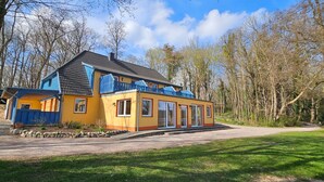 A yellow building with blue accents, a balcony, and a paved driveway. - Apartment Karpfen 4 by Interhome (Neukloster)