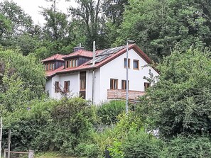 A two-story house with a red-tiled roof, surrounded by dense greenery. - Lechrauschen Landsberg by Interhome (Landsberg)