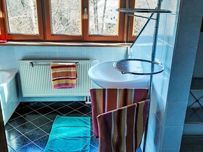 A bathroom with a white radiator, a sink, and a window with a view of trees. - Lechrauschen Landsberg by Interhome (Landsberg)