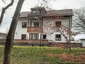 A two-story building with a balcony, a bench, and a well-maintained lawn. - Lechrauschen Landsberg by Interhome (Landsberg)