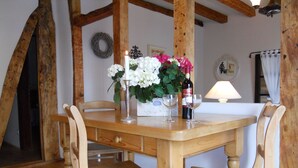 A wooden dining table with two chairs, a candle, and a bottle of wine. - Weyerhof by Interhome (Kobern-Gondorf)