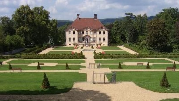 A large, symmetrical building with a central entrance, surrounded by well-manicured lawns and hedges. - im Teutoburger Wald by Interhome (Schieder-Schwalenberg)