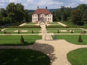 A large, symmetrical building with a central entrance, surrounded by well-manicured lawns and hedges. - im Teutoburger Wald by Interhome (Schieder-Schwalenberg)