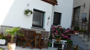 A residential building with a white exterior, a tiled roof, and a small front yard with a lawn and potted plants. - im Teutoburger Wald by Interhome (Schieder-Schwalenberg)