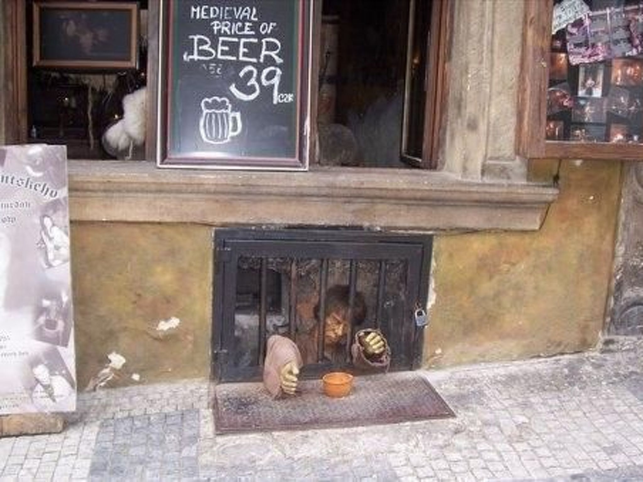 Un pub de temática medieval con un cartel de pizarra que indica el precio de la cerveza.