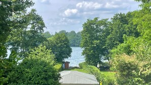 A lakeside property with a small house, surrounded by dense greenery and trees. - Ferienwohnung Seeweg 4 by Interhome (Lychen)