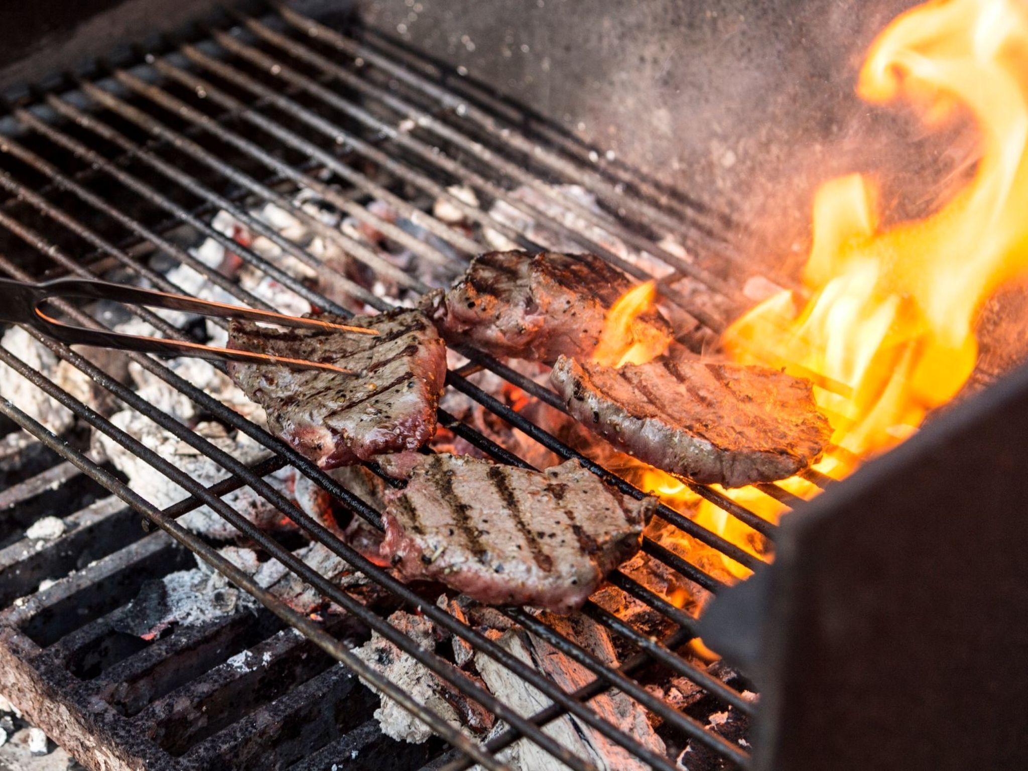 A grill with meat being cooked over an open flame.