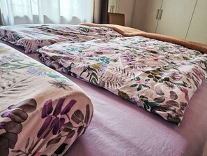A room with two beds, each with a floral-patterned bedspread. - Kuschelnest Oase by Interhome (Todtmoos)