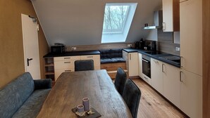 A compact kitchen with a dining area, a built-in oven, and a window providing natural light. - Appartement mit Balkon by Interhome (Lasel)