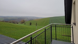 A balcony with a view of rolling green hills and distant landscapes. - Appartement mit Balkon by Interhome (Lasel)