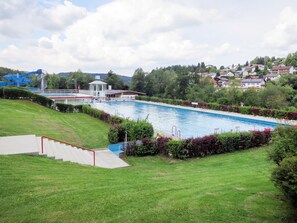 A swimming pool with a lifeguard tower, surrounded by green grass and bushes. - Luxuschalet im Forstgut - Raum für wertvolle Zeit by Interhome (Regen)