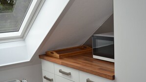 Una cocina con tragaluz, microondas y encimeras de madera.