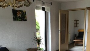 Una sala de estar con un sofá azul oscuro, una mesa de centro de madera y una planta en maceta.