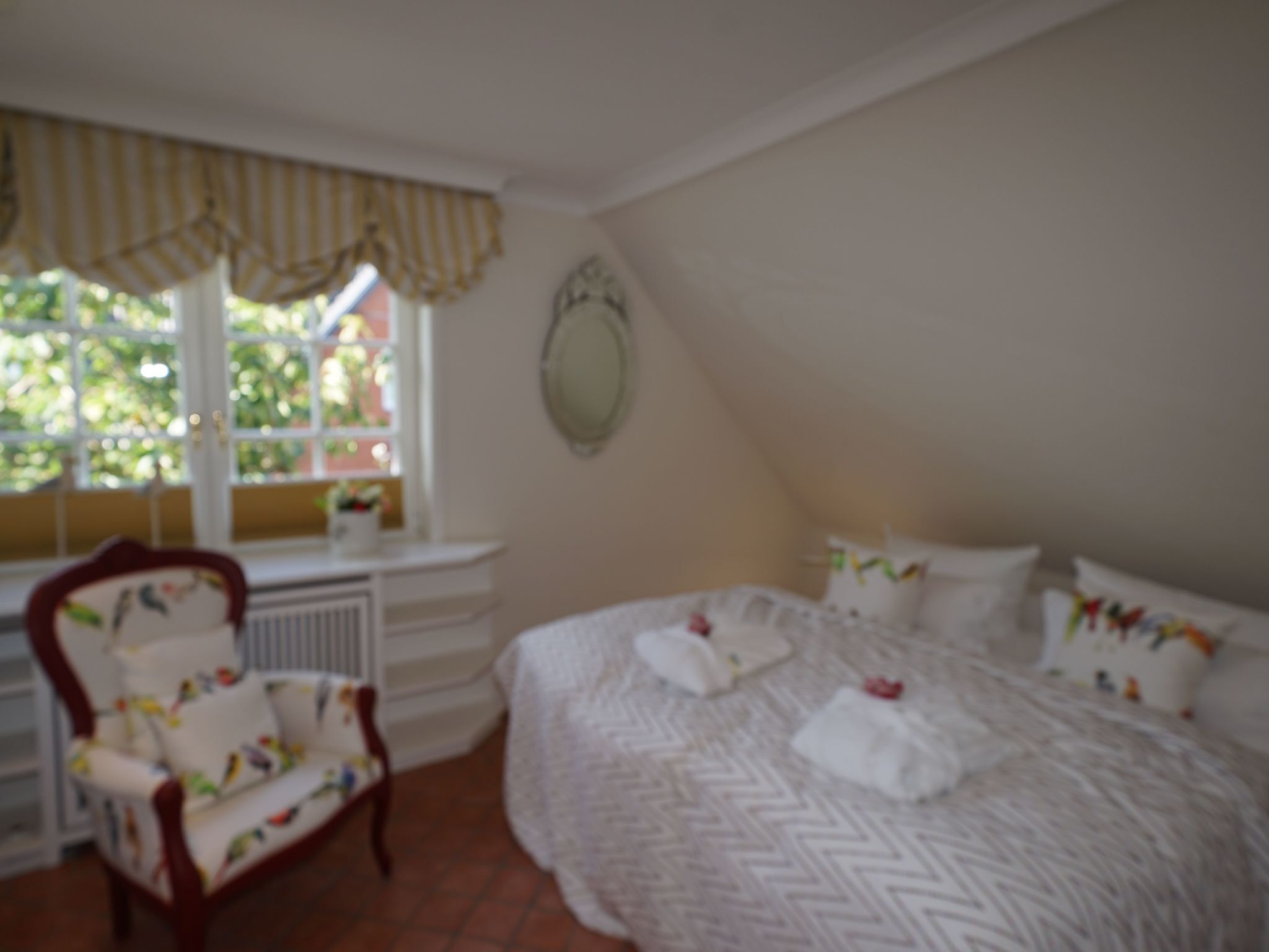 Une chambre à coucher avec un lit, une chaise, une fenêtre et un radiateur.