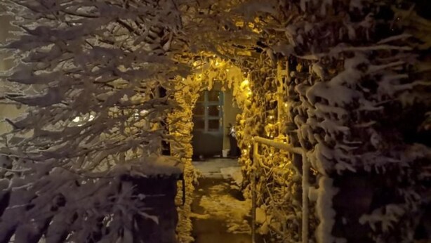 Un chemin enneigé menant à l’entrée d’un bâtiment.