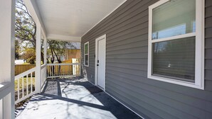 A covered porch with a white railing, a door, and a window. - 4 Min to Downtown | 11 to Elon | Car Rental Avail. (Burlington)