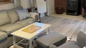A cozy living room with a sofa, a coffee table, and a fireplace. - im Fachwerkstil mit Sauna und Garten by Interhome (Thomasburg)