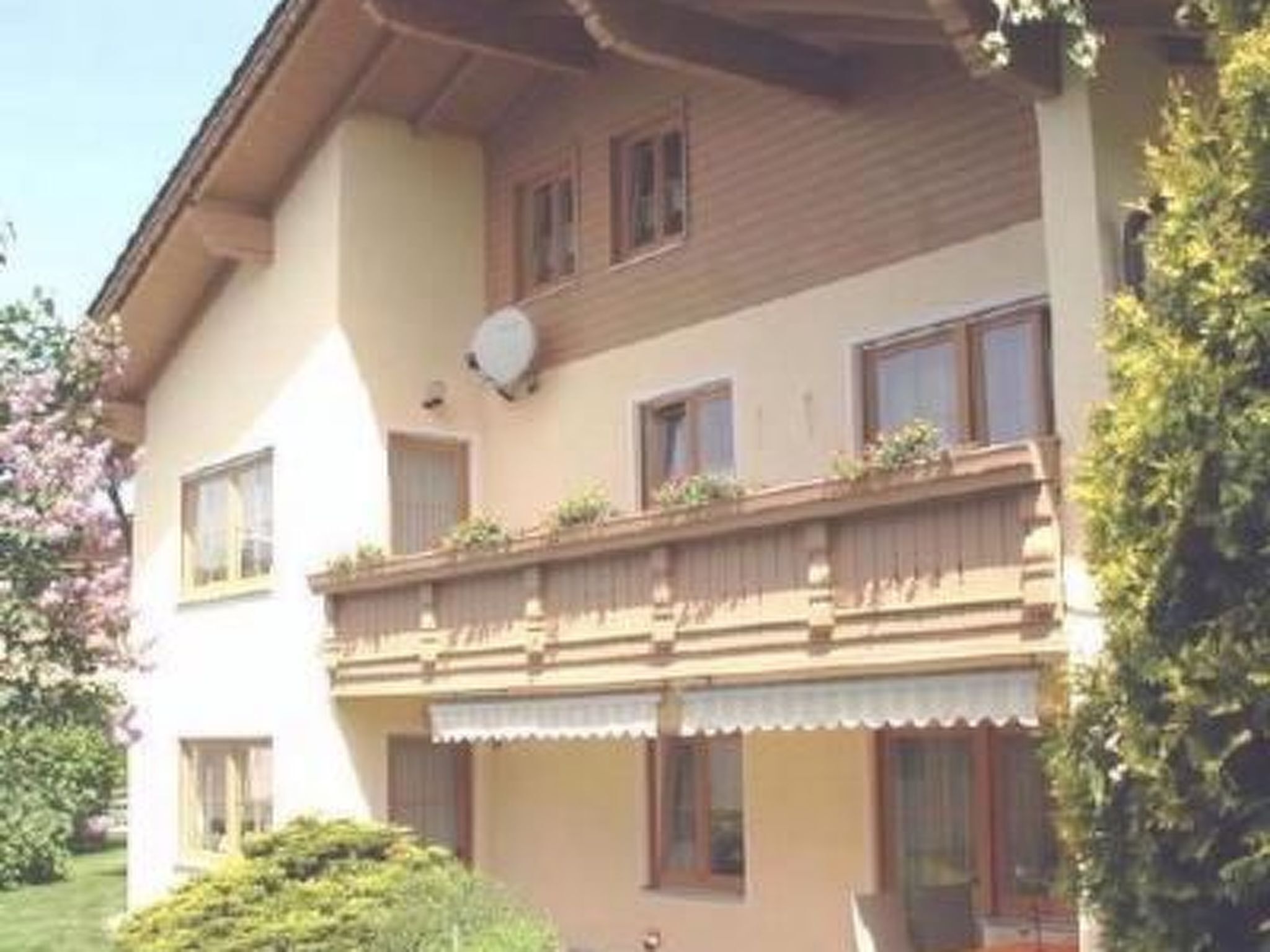 Un immeuble de deux étages doté d’un balcon, de fenêtres et d’une antenne parabolique.