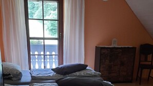 A bedroom with a bed, a dresser, and a window with curtains. - in Horben mit Großem Garten by Interhome (Horben)