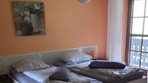 A bedroom with two beds, a ceiling light, and a window with curtains. - in Horben mit Großem Garten by Interhome (Horben)