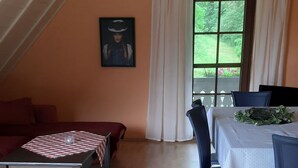 A cozy room with a dining table set for two, a sofa, and a painting on the wall. - in Horben mit Großem Garten by Interhome (Horben)