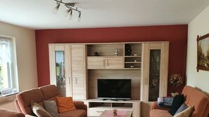 Ett vardagsrum med två soffor, ett soffbord och en tv.