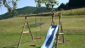 A wooden swing set with a slide in a grassy field. - für 11 Personen und 1 Kind by Interhome (Birresborn)