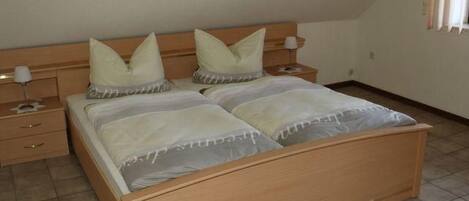 Een slaapkamer met een houten bed, twee nachtkastjes en een bedtafel.