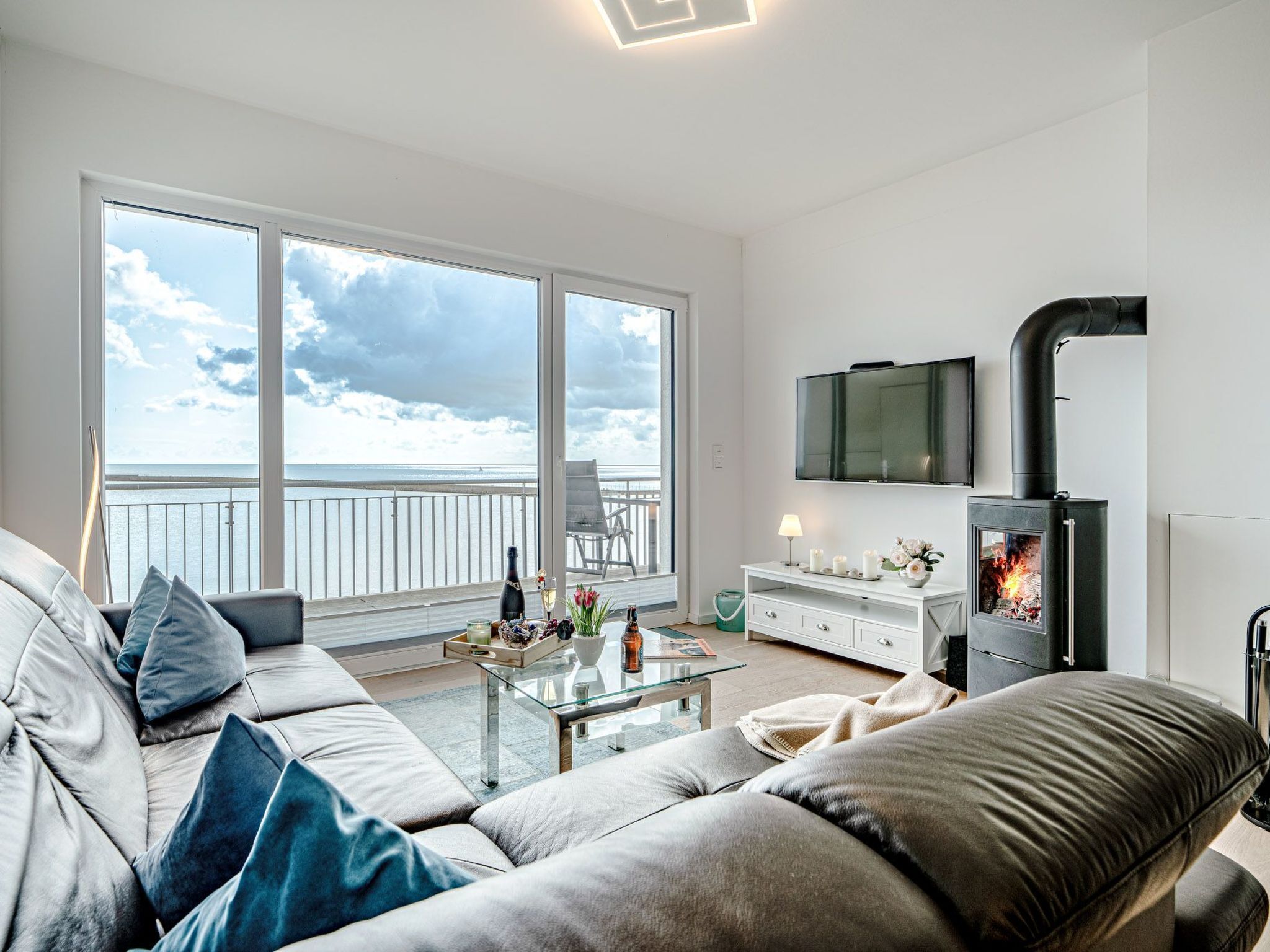 A modern living room with a sofa, a glass coffee table, and a fireplace.
