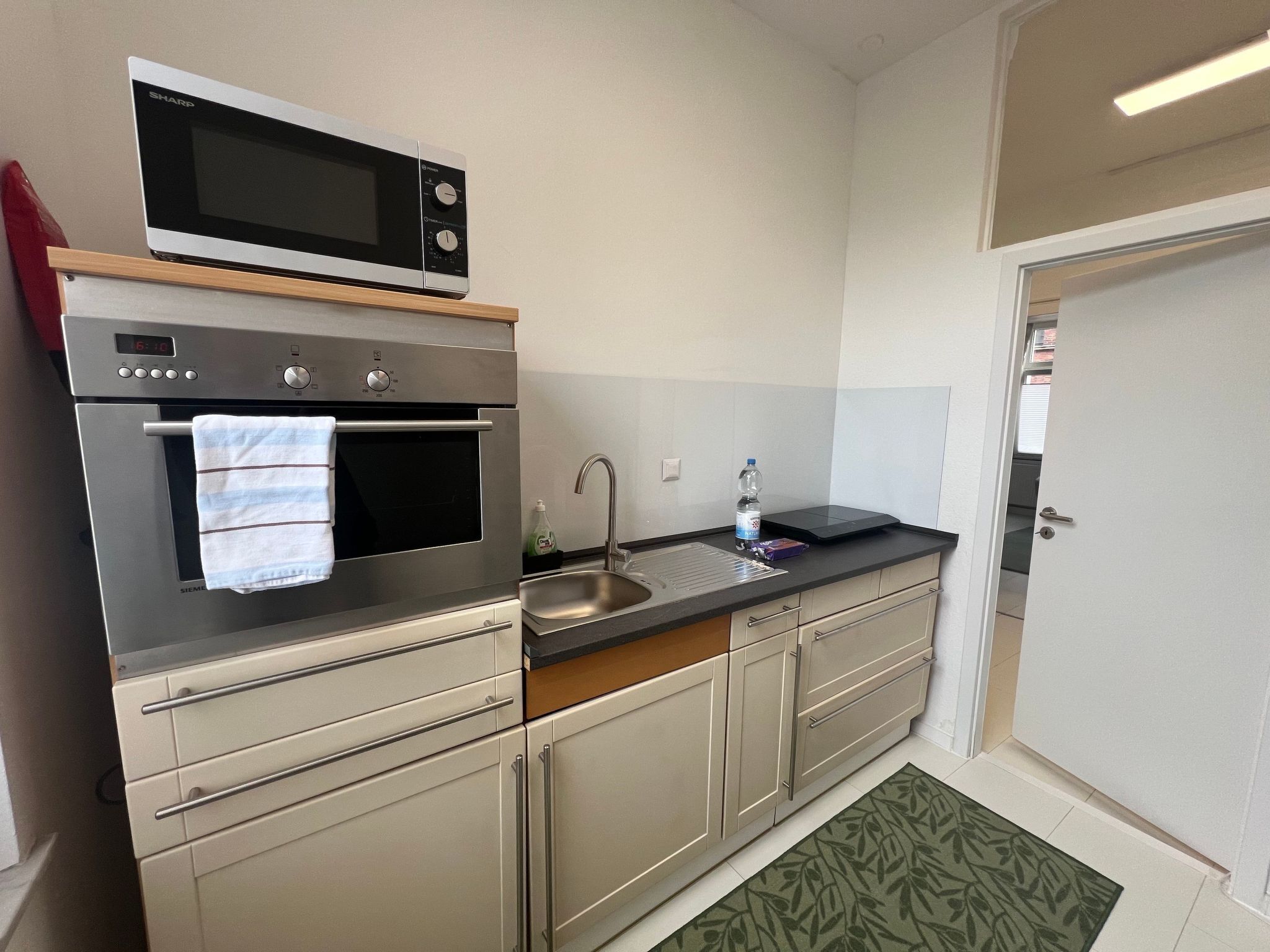 Een koelkast, een microgolfoven, een oven, kookgerei, borden en bestek