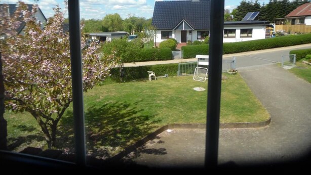 Ein Wohngebiet mit Häusern, einem gepflegten Rasen und blauem Himmel.