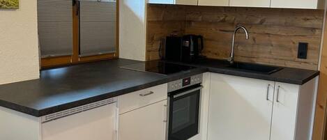 Réfrigérateur, un four, vaisselle et ustensiles