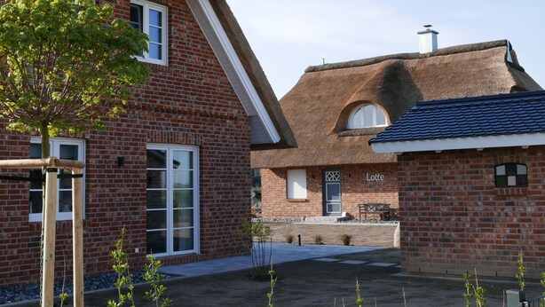 A brick house with a thatched roof and a smaller attached building with a blue tiled roof. - Vacation home Lotte by Interhome (Groß Schoritz)