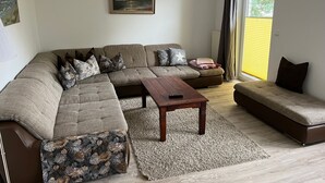Una sala de estar con un sofá modular, una mesita y un cuadro en la pared.