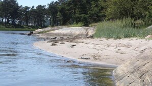 A riverbank with a sandy beach and large rocks. - Wunderschönes Cottage "Traum von Wald und Meer" by Interhome (Stenungsund)