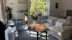 A well-lit room with a large window, a sofa, a table, and a mirror. - Wunderschönes Cottage "Traum von Wald und Meer" by Interhome (Stenungsund)