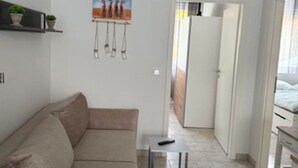 A modern living room with a beige sofa, a white throw blanket, a small table, and a painting on the wall. - Panorama 180° by Interhome (Kitzingen)