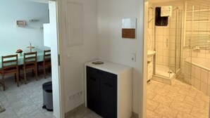 A compact living space with a kitchenette, a dining area, and a shower. - Panorama 180° by Interhome (Kitzingen)