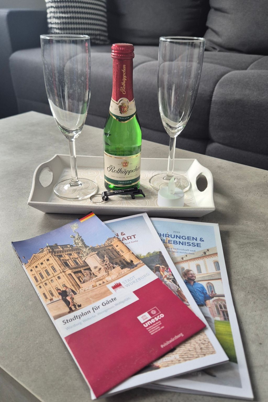 Une bouteille de bière Roteppich, deux verres et des brochures sur une table.