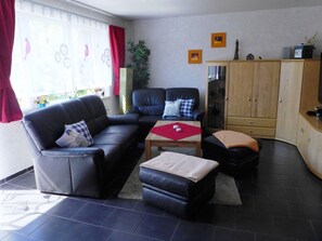 Ein Wohnzimmer mit einer Couch, einem Couchtisch und einem Schrank.
