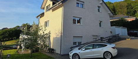 A two-story house with a sloped roof, a garage, and a driveway.