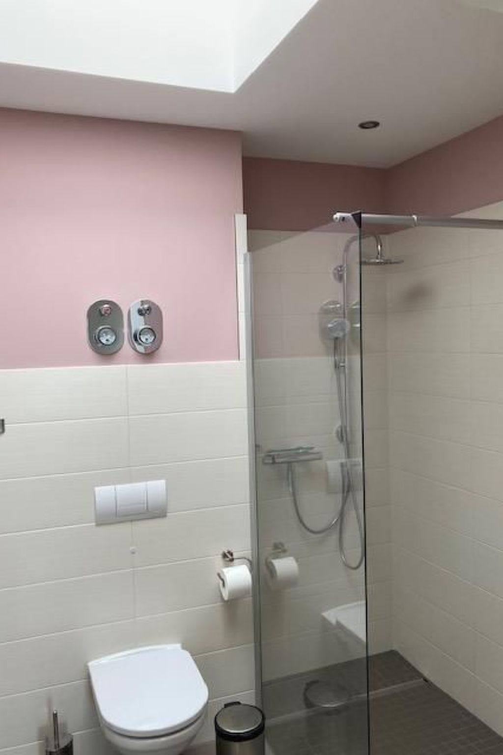 Ein Badezimmer mit Duschkabine, Toilette und zwei Schlüsseln an der Wand.