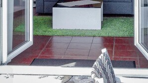 A living room with a blue sofa, red and beige cushions, a white coffee table, and a colorful abstract painting on the wall. - Apartment mit Terrasse nahe Schweizer Grenze by Interhome (Weil am Rhein)